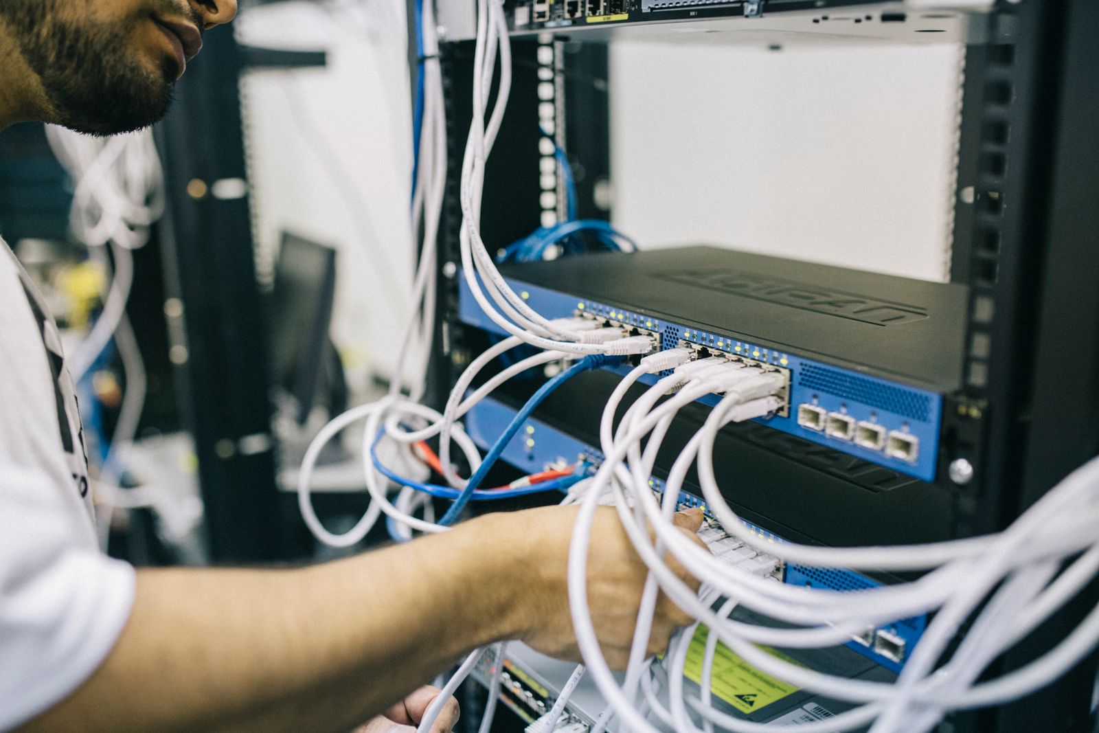 Kỹ thuật viên đi dây mạng trong tủ rack máy chủ